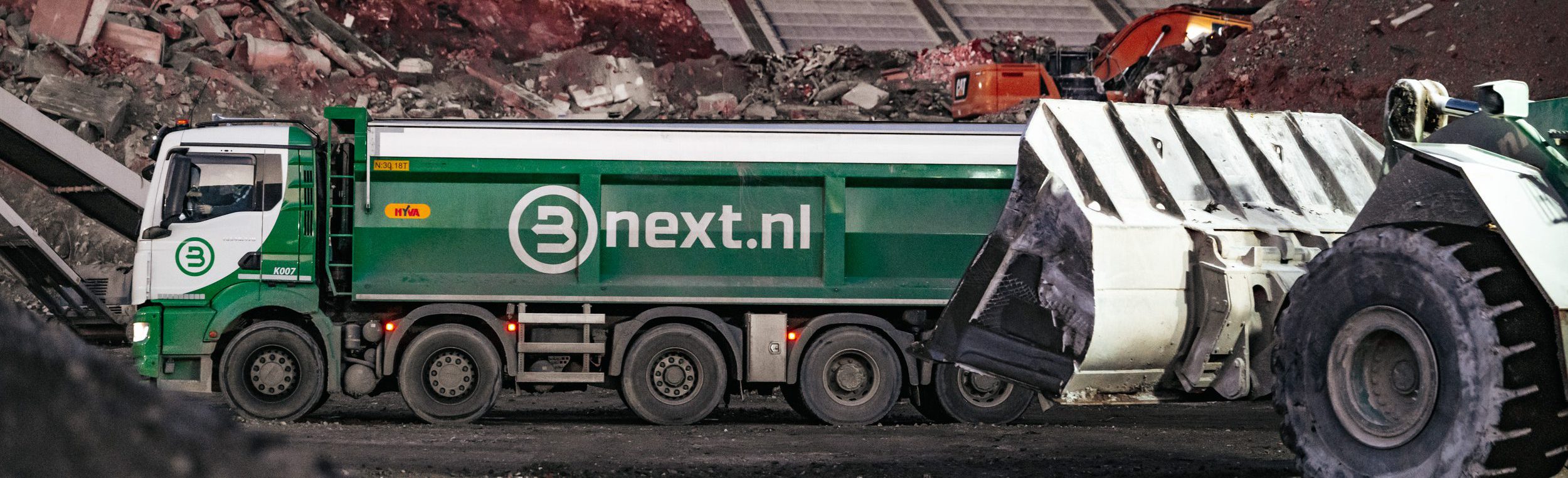 Een vrachtwagen en een shovel op het terrein van de vestiging in Amsterdam